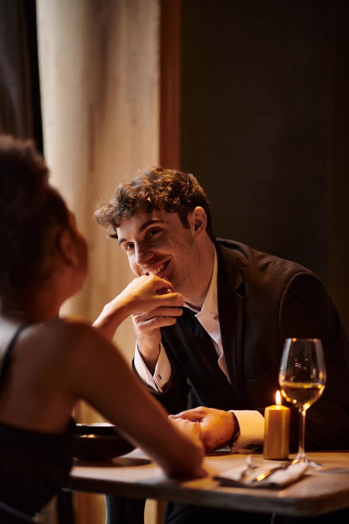 Dos personas conversan y sonríen durante una cena a la luz de una vela