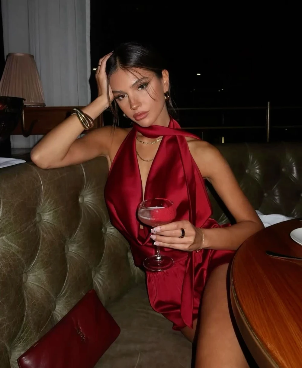 Mujer con vestido borgoña en una mesa de restaurante