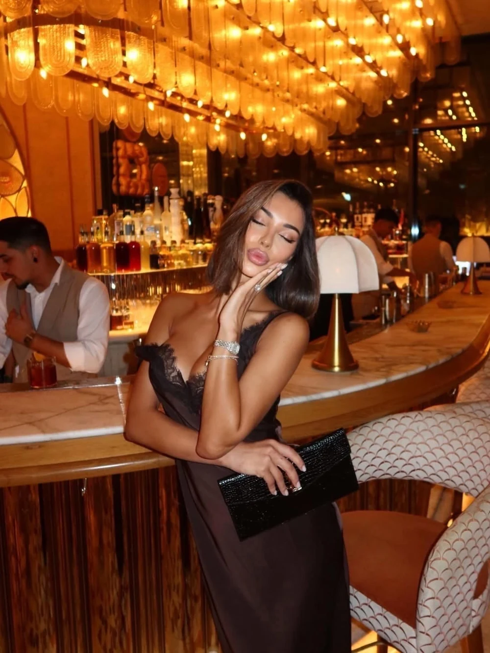 Mujer con vestido de noche en un restaurante de luz dorada